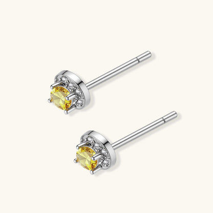 Dainty sterling silver stud earrings with yellow moissanite center stones surrounded by white halo stones