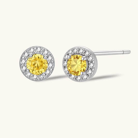 Dainty sterling silver stud earrings with yellow moissanite center stones surrounded by white halo stones