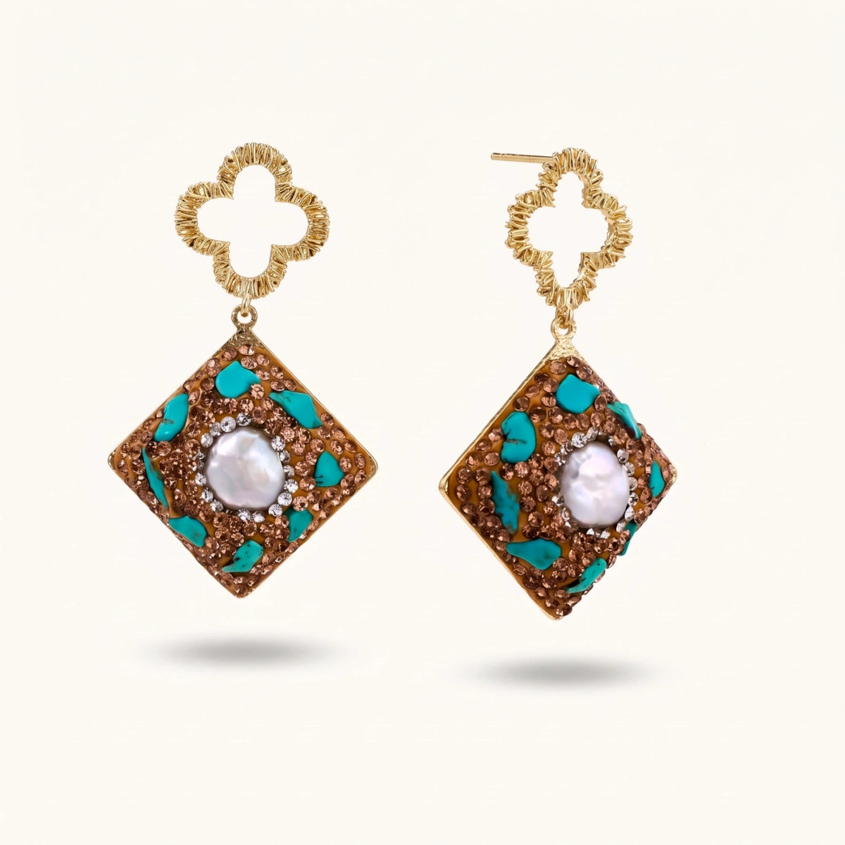 Gold-plated drop earrings with quatrefoil studs, diamond-shaped pendants featuring baroque pearls, turquoise stones, and amber crystals