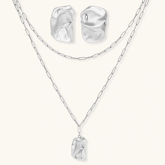 Modern textured hoop earrings and layered chain necklace with liquid metal pendant in silver and gold finishes.