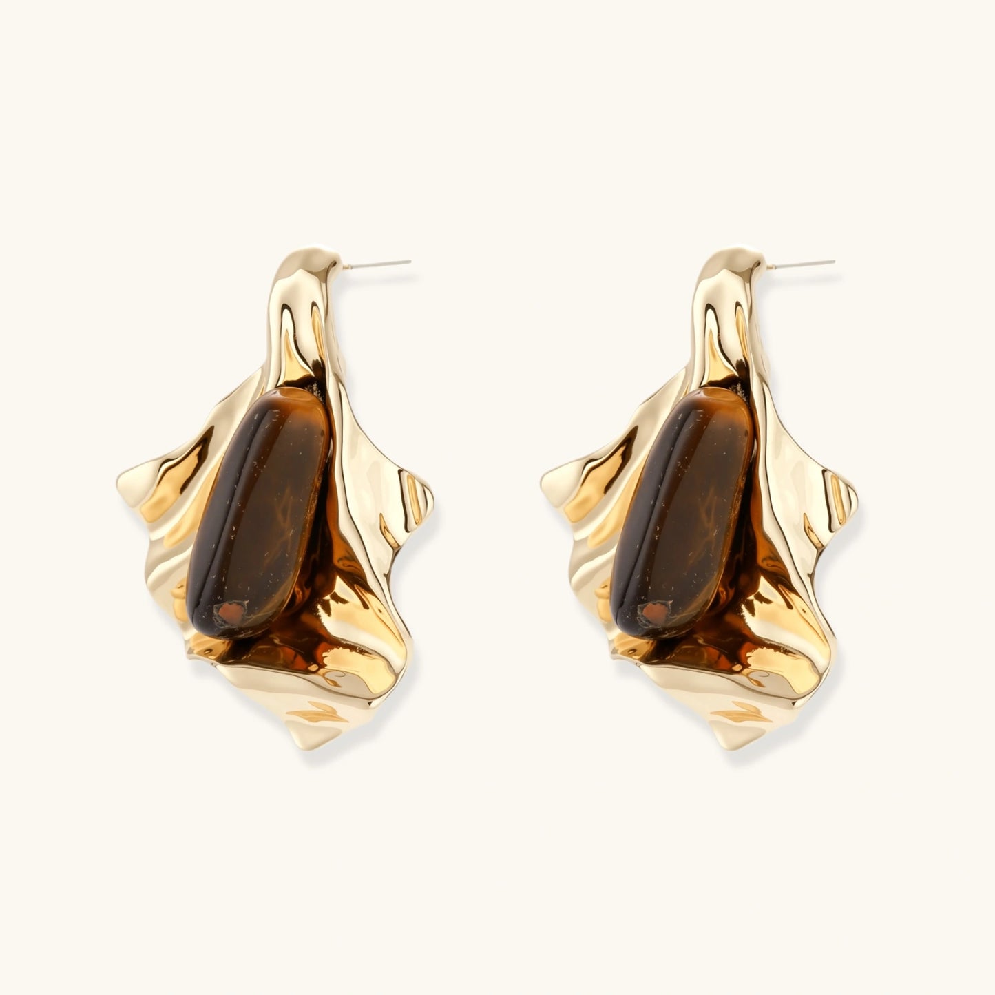 Sculptural stud earrings with organic twisted metal design holding brown gemstones, shown in gold and silver finishes.