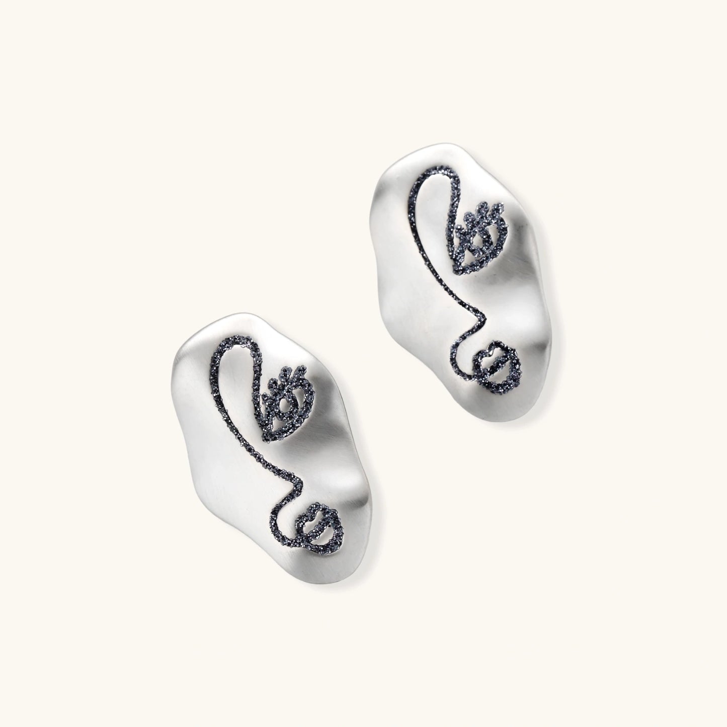 Artistic ear-shaped earrings with minimalist face line art on clear eco-zinc alloy base with sterling silver posts.