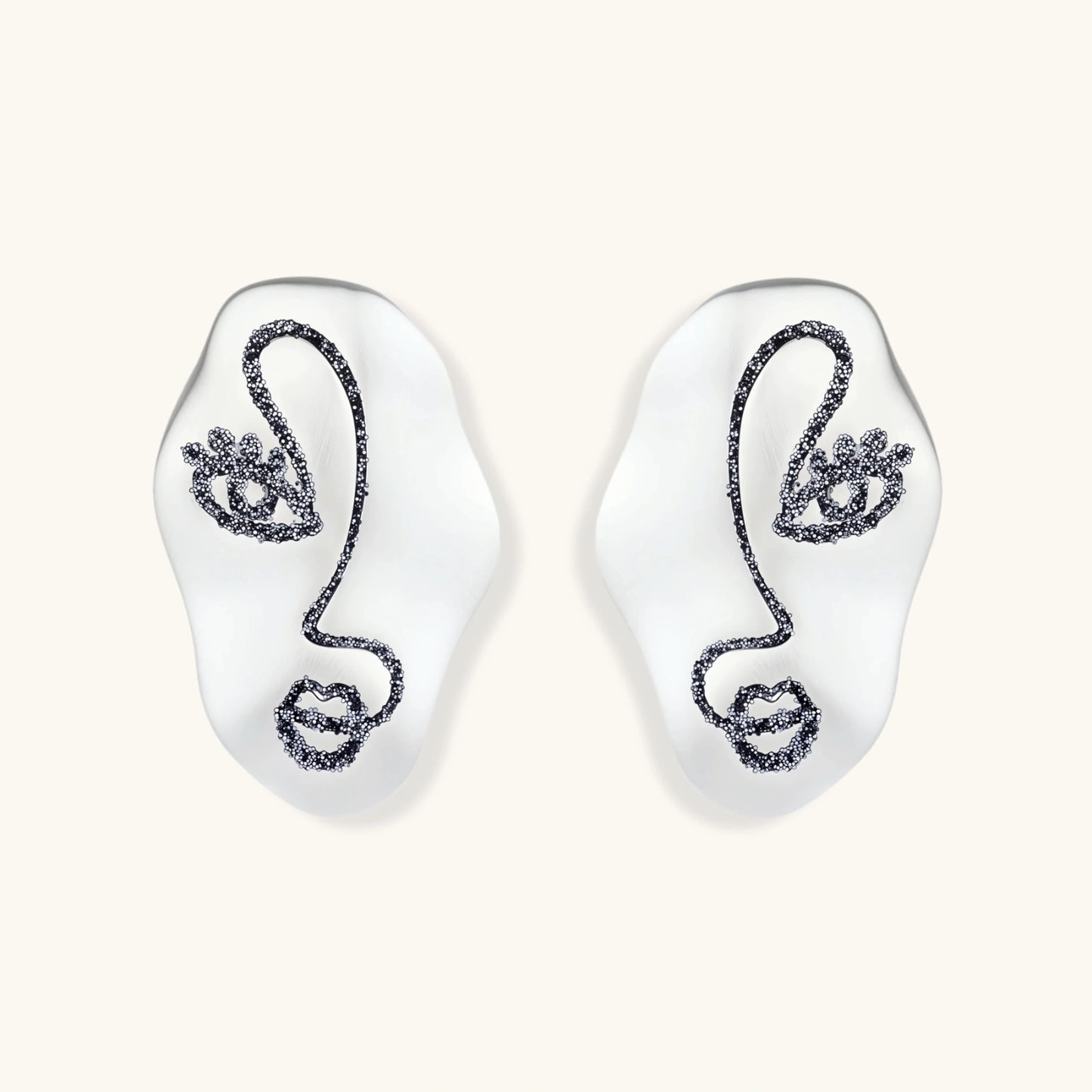 Artistic ear-shaped earrings with minimalist face line art on clear eco-zinc alloy base with sterling silver posts.