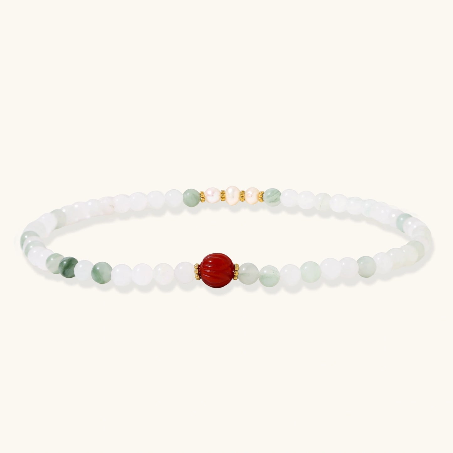Three layered white beaded bracelets with carved orange agate lotus centerpiece and freshwater pearls on cream background.