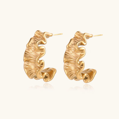 Sculptural gold hoops with textured wave patterns and rippled surface in 14K plating, shown from front and back angles