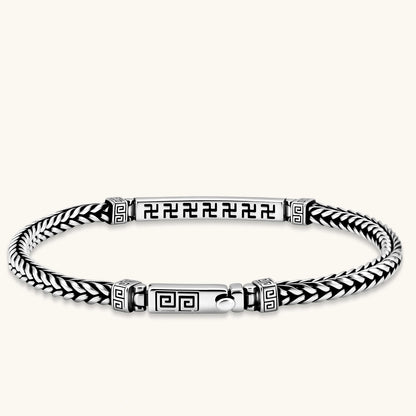 Silver stainless steel men's bracelet with braided foxtail chain, Greek key engraved bar, and decorative cube connectors.
