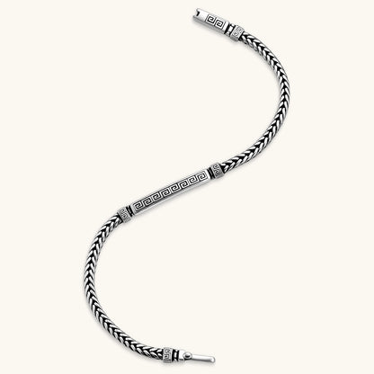 Silver stainless steel men's bracelet with braided foxtail chain, Greek key engraved bar, and decorative cube connectors.